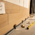 Parquet sur les murs avec rails et fixation, outils en chantier